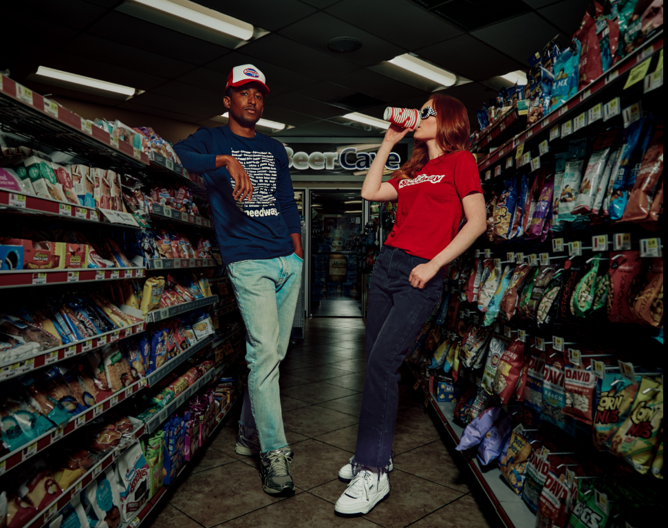 Man and woman in a Speedway store wearing Speedway merch