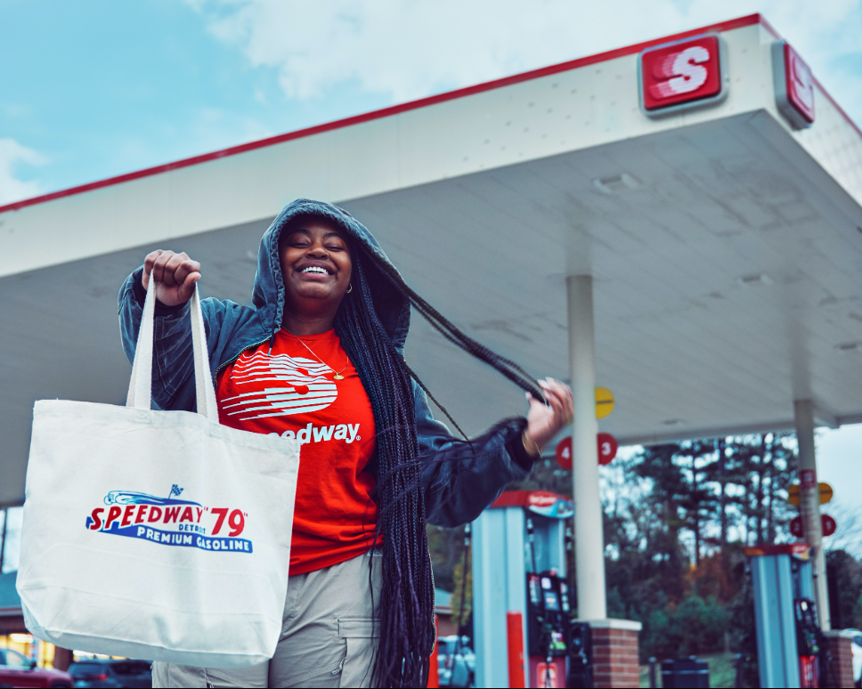Woman wearing Speedway merch and holding a tote bag