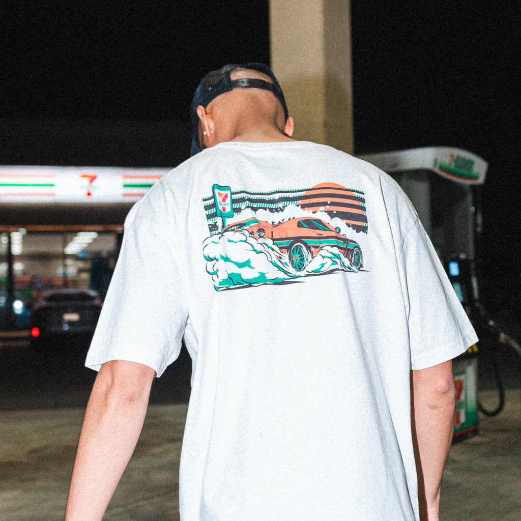 Man at a gas station wearing a Cars of 7-Eleven t-shirt
