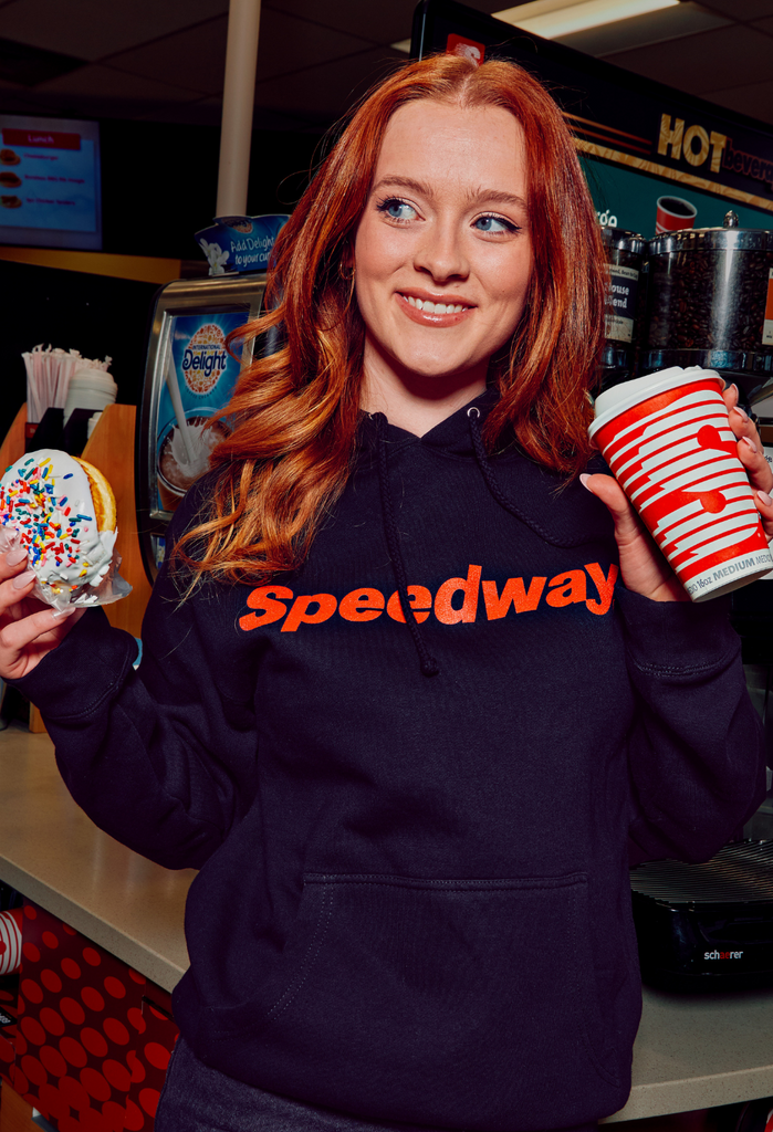 Woman wearing a Speedway sweatshirt. Shop the Speedway collection